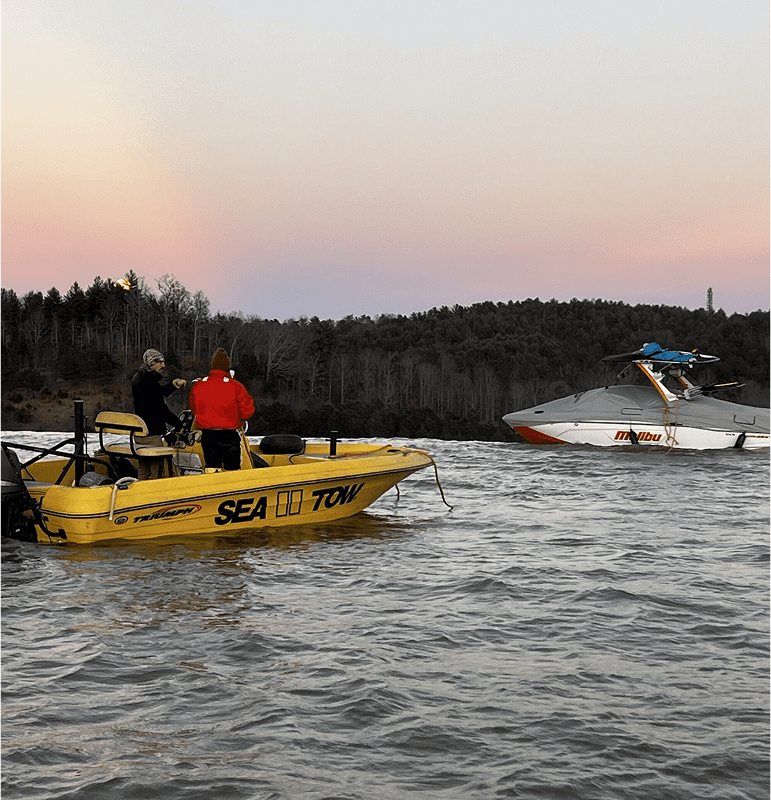 Two boats on a lake during sunset with people onboard.